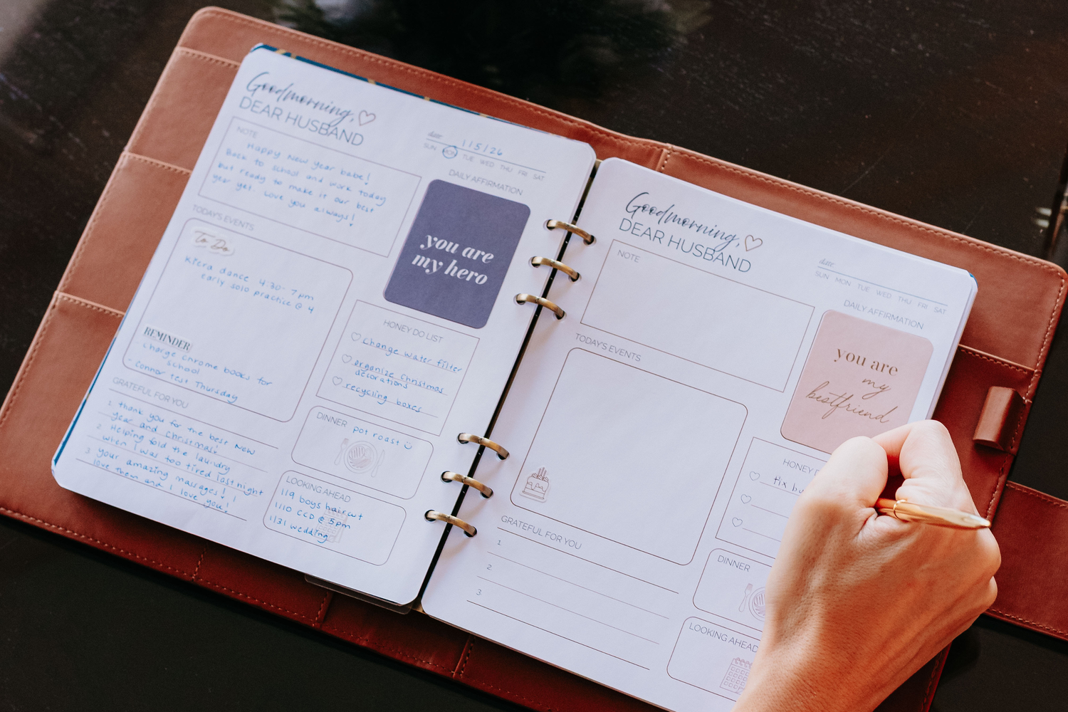 Woman writing in the Honor Him Luxe Marriage Transformation System on a table