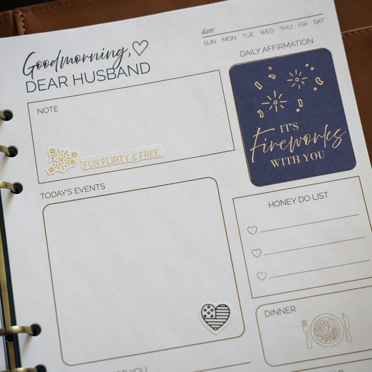 Fourth of July affirmation stickers from the Honor Him Thru Holidays Affirmation Sticker Book displayed inside the Honor Him Marriage Transformation System planner.