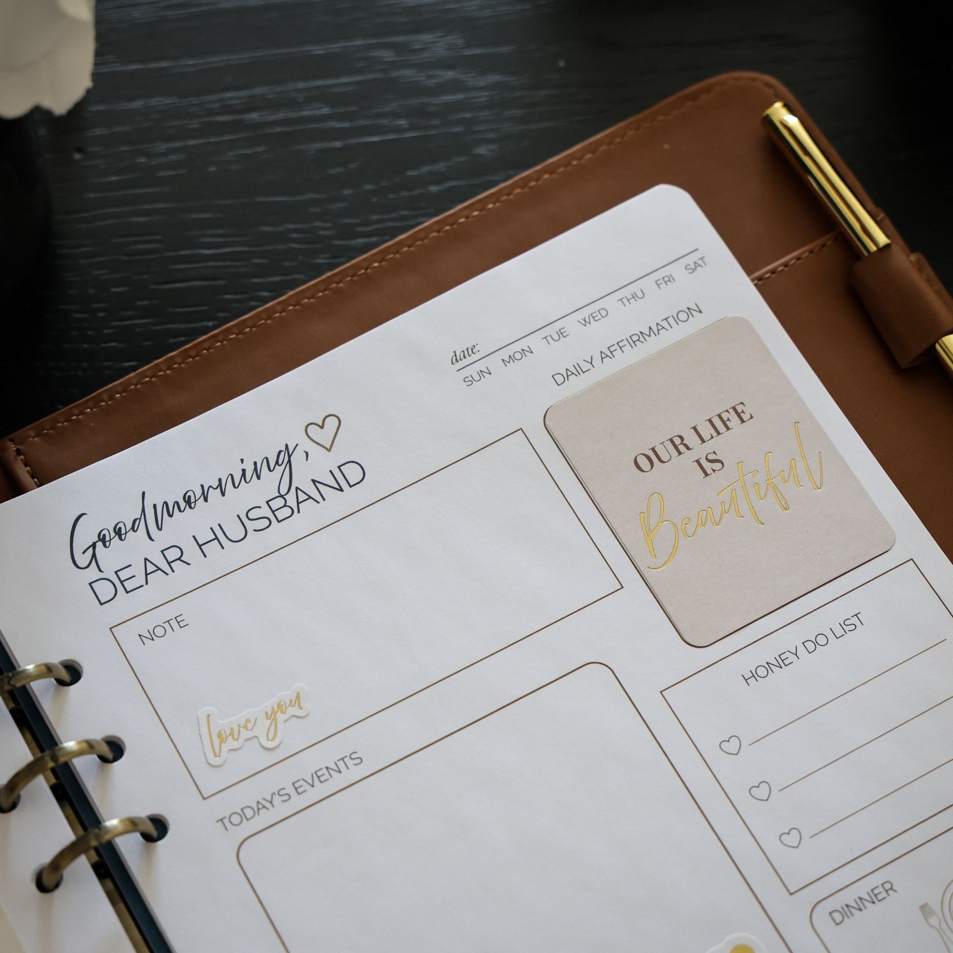 Honor Him Thru Words Affirmation Sticker Book displayed inside the Honor Him marriage planner with affirmation stickers.